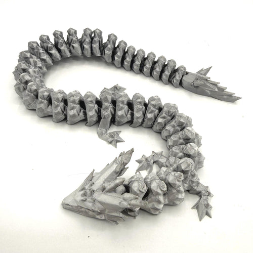 A silver 3D-printed articulated fantasy creature or dragon-like monster, shown coiled on a plain white background.