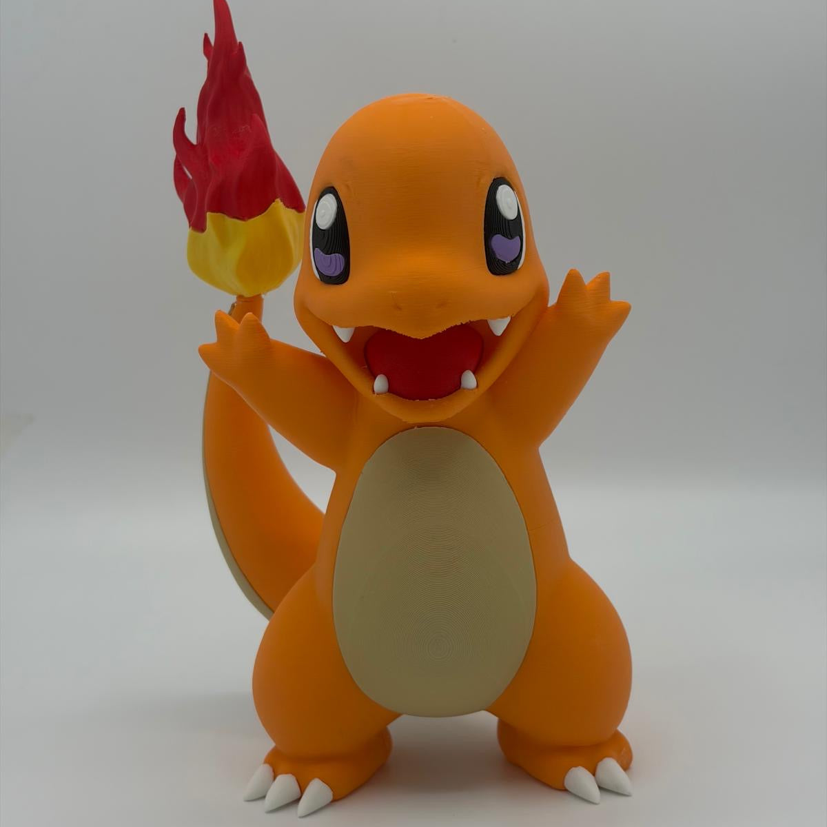 A Charmander figurine with a red and yellow flame, standing on a light background.
