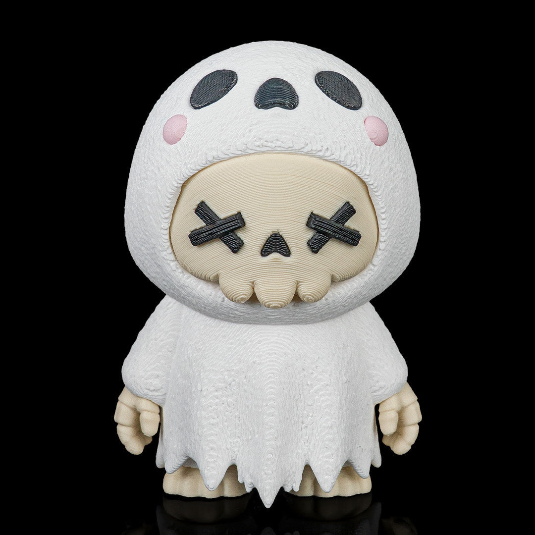 A stylized collectible figure of a skull-like character wearing a white ghost-like hooded outfit, photographed against a solid black background with a reflective surface below.