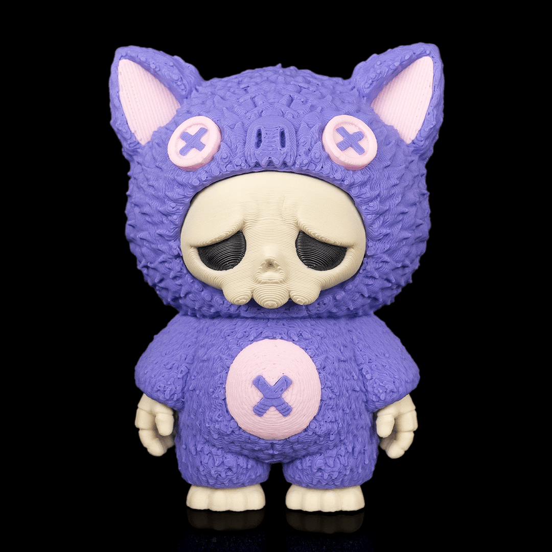 A stylized collectible figure of a purple cat-like character wearing a fuzzy textured suit, with pale pink inner ears, a cream skull face, and a pink circular patch on the chest with a purple X, shown against a black background.