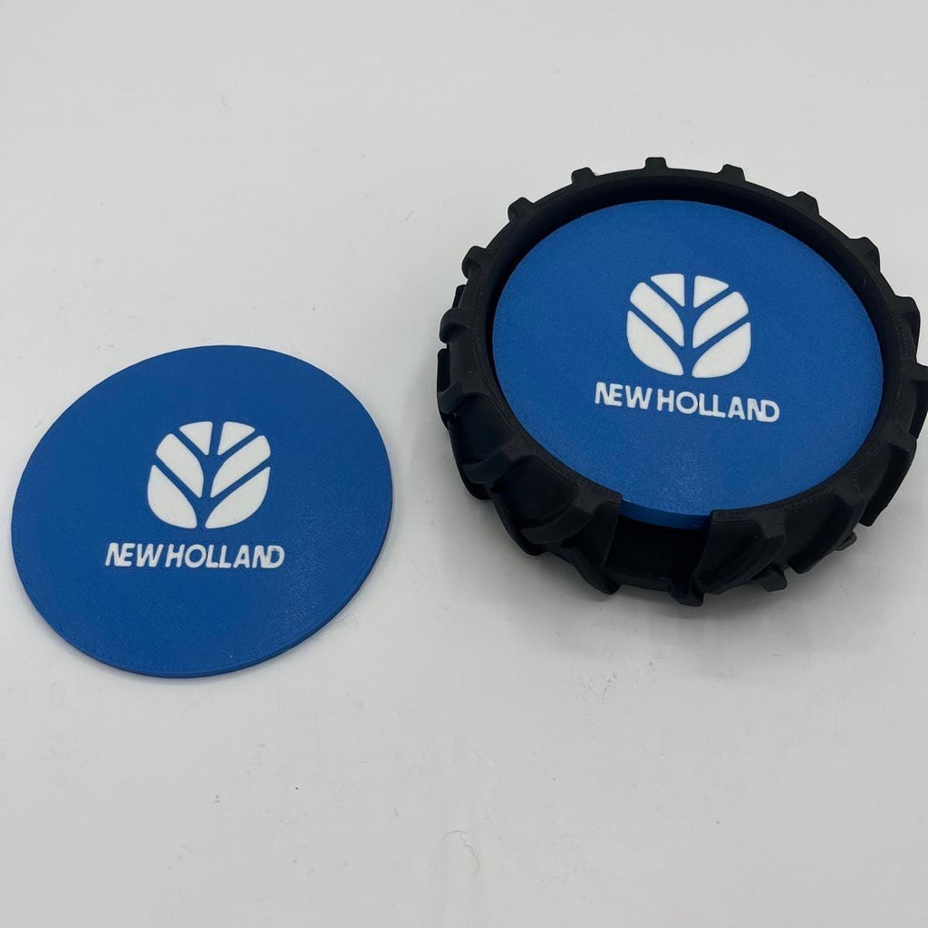 Two New Holland branded circular blue and white coasters, one flat round and one raised with a black textured rim, on a plain light background.